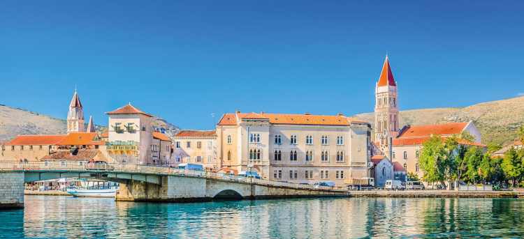 Pastel coloured buildings and stone bridge on Trogir waterfront | Trogir, Croatia 