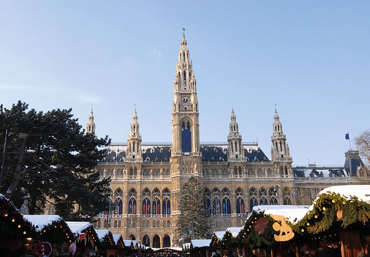 Snow capped Vienna city hall with roofs of Yuletide market stalls | Vienna, Austria 
