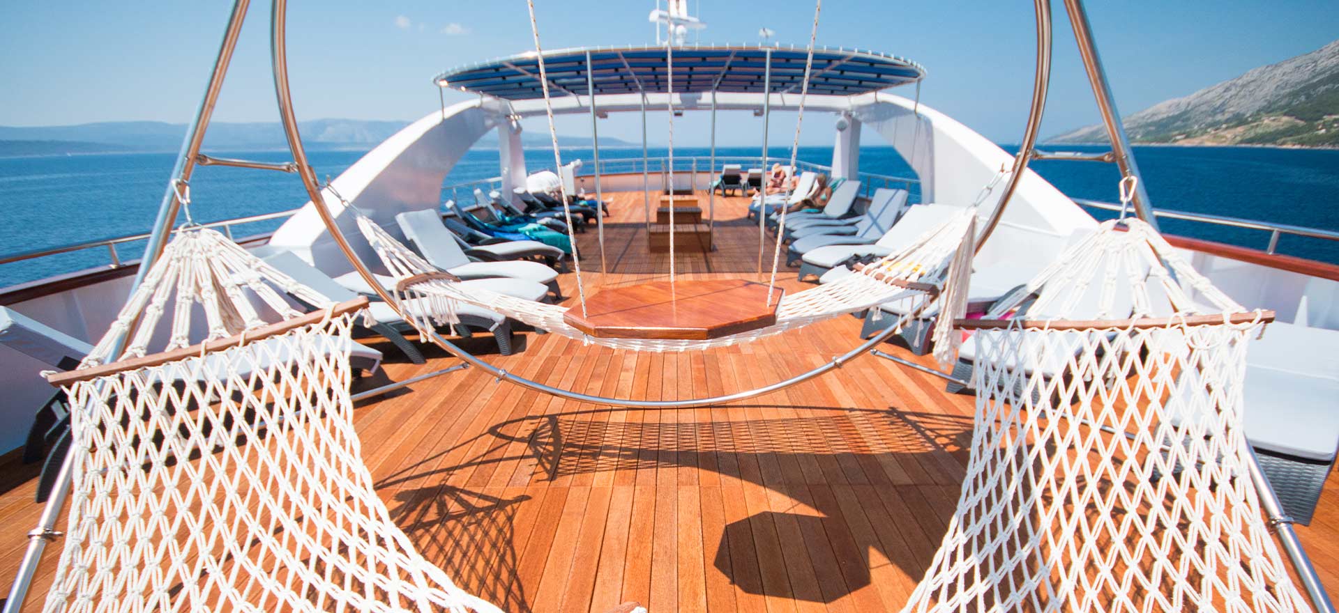 Two hammocks on top deck of yacht cruise in the sun | Yacht Cruises